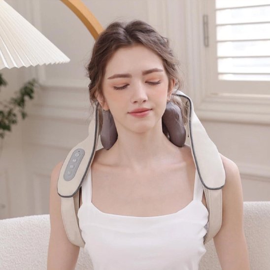 femme utilisant un appareil de massage pour les épaules, nuque de couleur beige