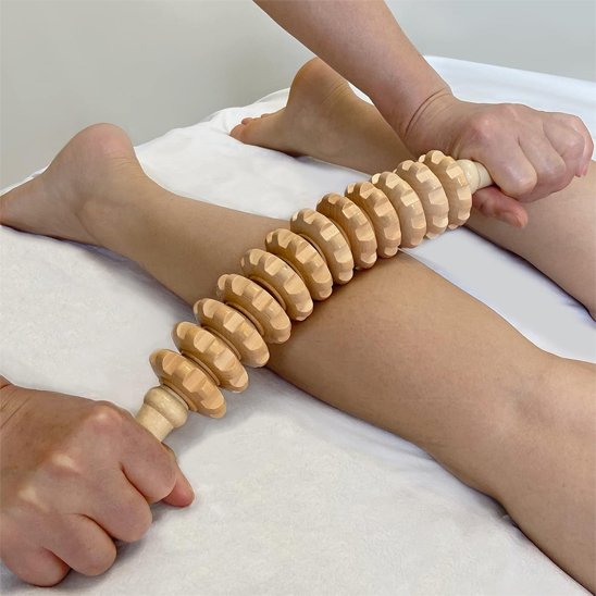 Massage des mollets avec rouleau de massage ErgoRelief en bois cranté anticellulite