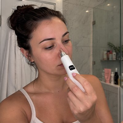 Femme nettoyant son nez avec aspirateur point noir​