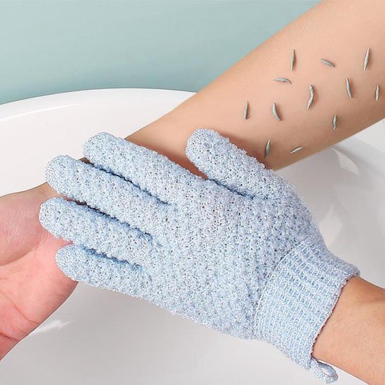 Gant exfoliant bleu clair utilisé sur le bras