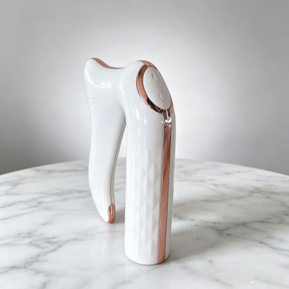 Gua sha électrique blanc et rose doré sur marbre